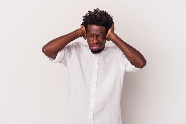 Young african american man isolated on white background  covering ears with hands.