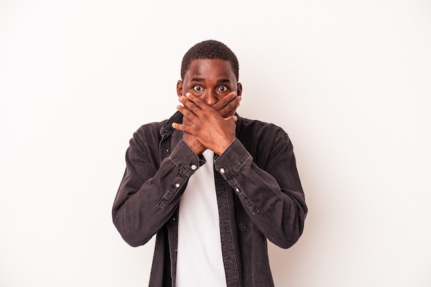 Young African American man isolated on white background shocked covering mouth with hands.