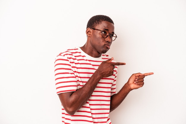 Young African American man isolated on white background shocked pointing with index fingers to a copy space.