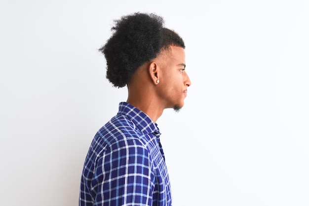 Young african american man wearing casual shirt standing over isolated white background looking to side relax profile pose with natural face with confident smile