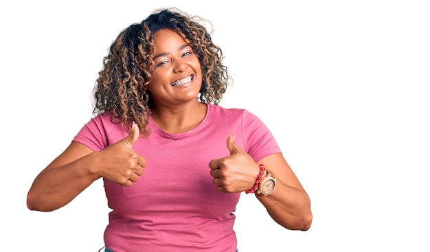 Young african american plus size woman wearing casual clothes success sign doing positive gesture with hand thumbs up smiling and happy cheerful expression and winner gesture