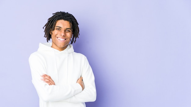 Young african american rasta man who feels confident, crossing arms with determination.