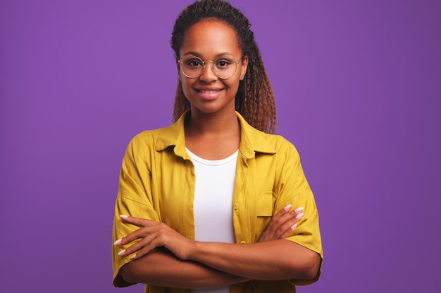 Young african american woman arms crossed in front of chest stands on studio