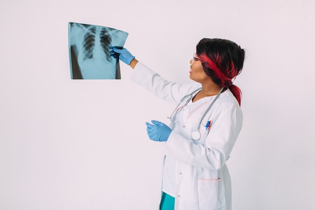 Young African American woman doctor in medical wear looking at x-ray image