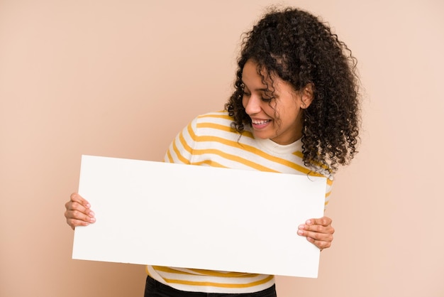 Young african american woman holding a banner isolated