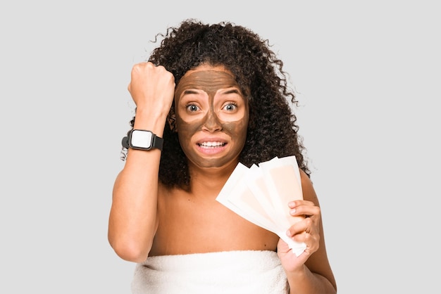 Young african american woman holding hair removal bands worried about hour isolated