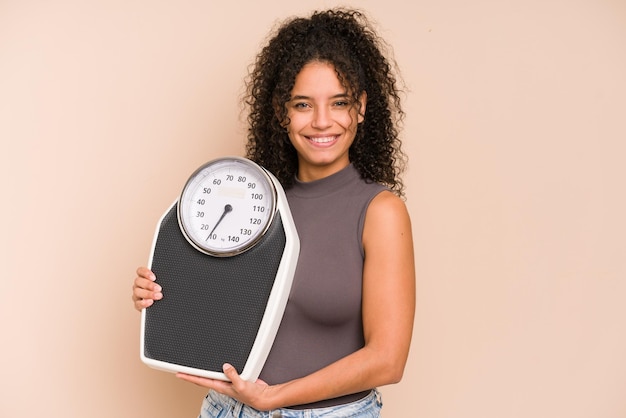 Young african american woman holding a scale isolated