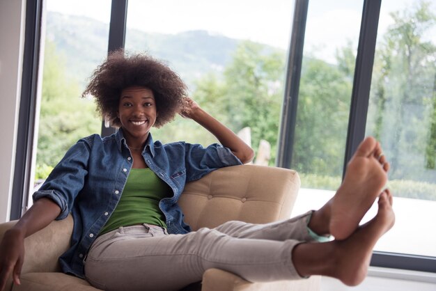 Young african american woman at home in the chair relaxing in her luxury home