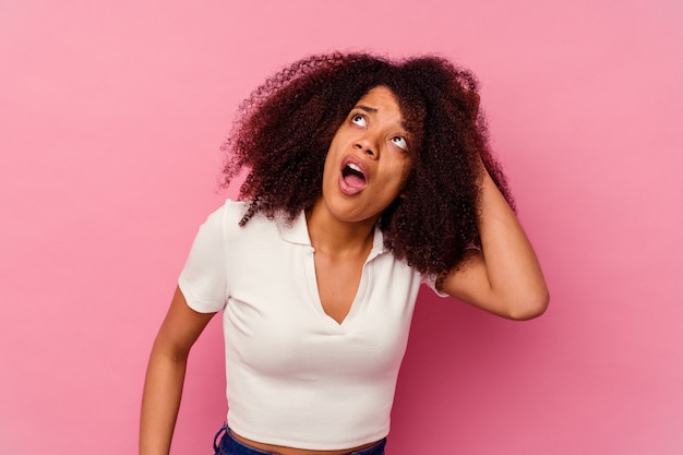 Young african american woman isolated on pink background being shocked, she has remembered important meeting.