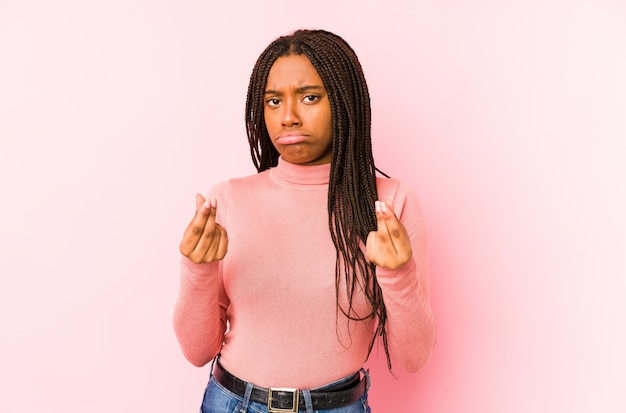 Young african american woman isolated on a pink wall showing that she has no money.