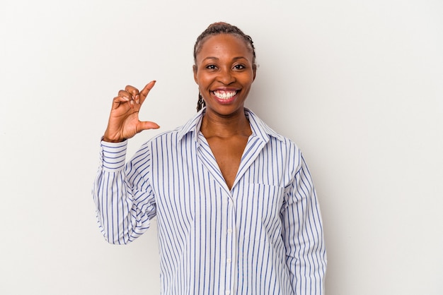 Young african american woman isolated on white background holding something little with forefingers, smiling and confident.