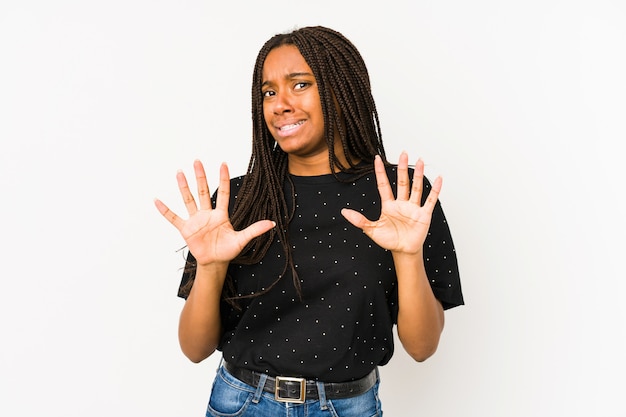 Young african american woman isolated on white wall rejecting someone showing a gesture of disgust.