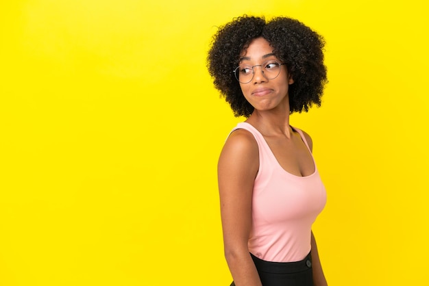 Young African American woman isolated on yellow background . Portrait