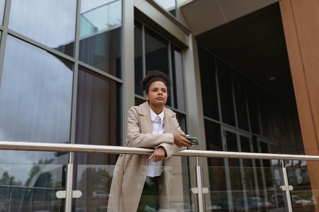 Young african american woman lawyer with a serious face on the background of a city building concept