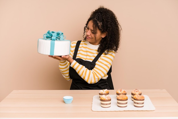 Young african american woman learning to make muffins and sweet cake