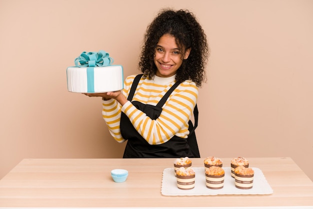 Young african american woman learning to make muffins and sweet cake