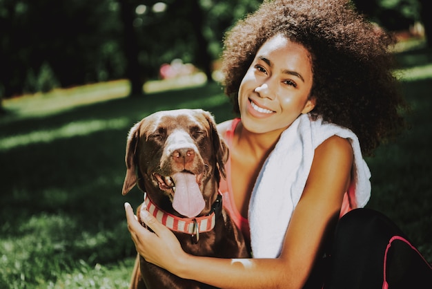 Young African American Woman Sitting with Dog.