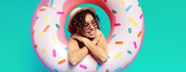 Photo a young african american woman smiles as she relaxes in a donutshaped pool float against a turquoise