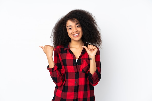 Young african american woman over wall pointing to the side