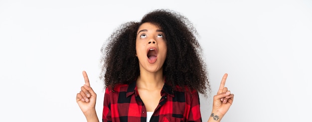 Young african american woman over wall surprised and pointing up