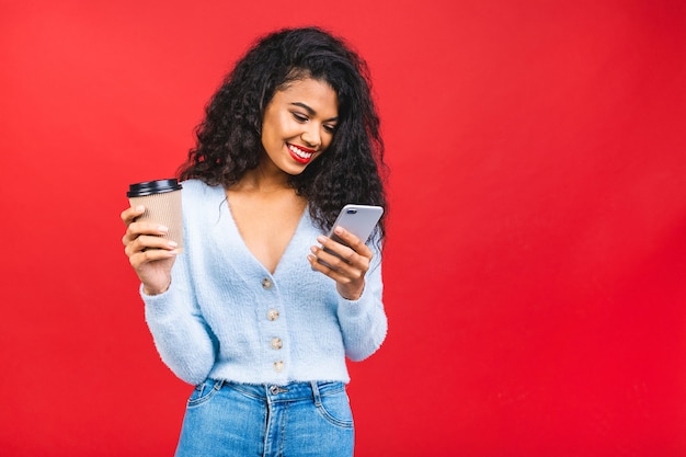 Young African American woman with red lips drinking coffee