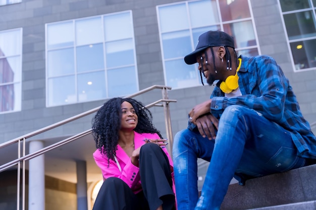 Young african american women talking in the city sitting down having fun