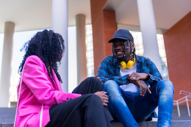 Young african american women talking in the city sitting down having fun