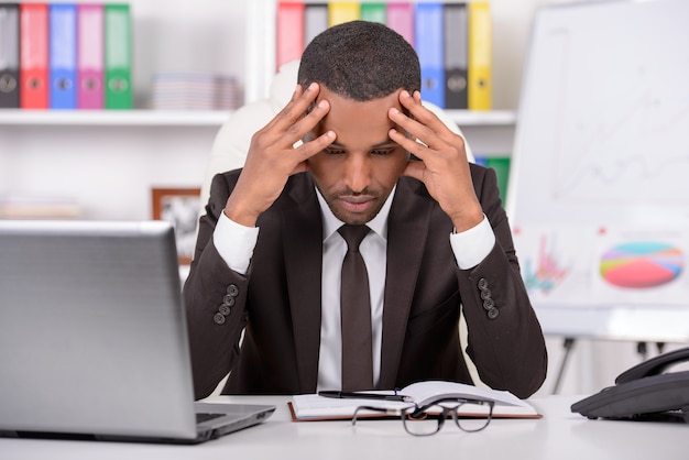 Young African businessman working in his office.