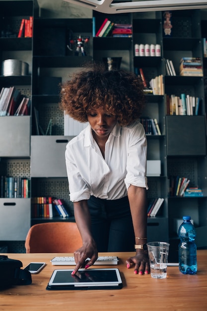 Young african businesswoman working with tablet in co-working office