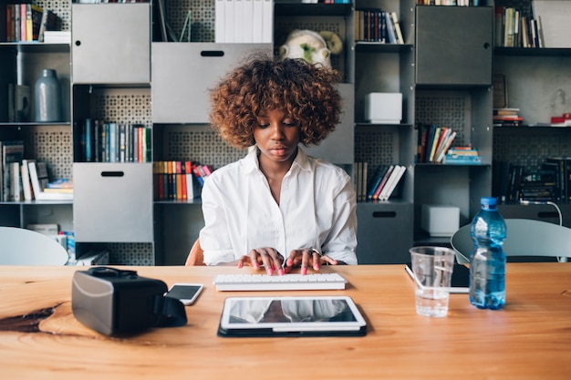 Young african businesswoman working with tablet in modern studio