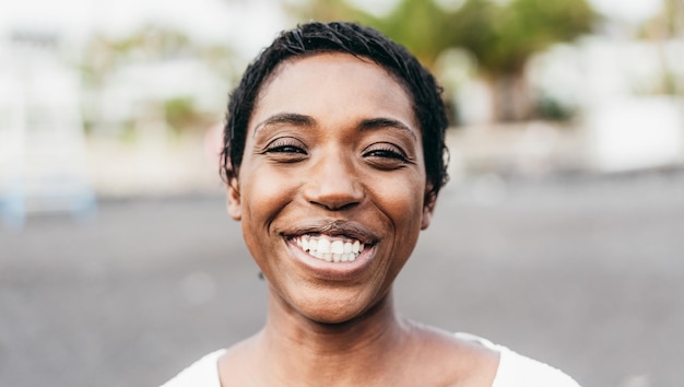 Young african girl smiling on camera outdoor - Focus on face