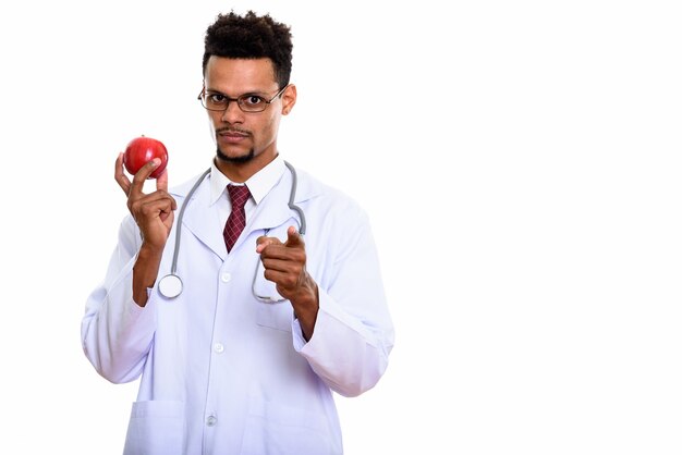 Young African man doctor holding red apple while pointing