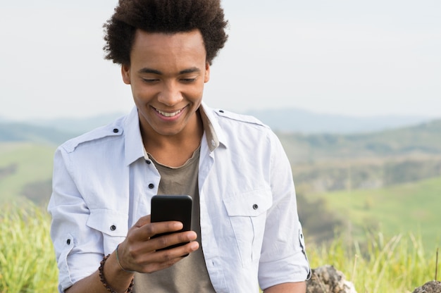 Young African Man Looking At Mobile Phone