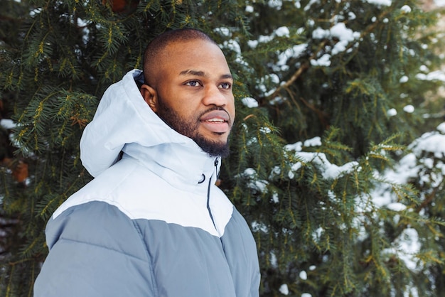 Young African man in park snow winter season city portrait