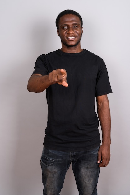 Young African man wearing black shirt on gray