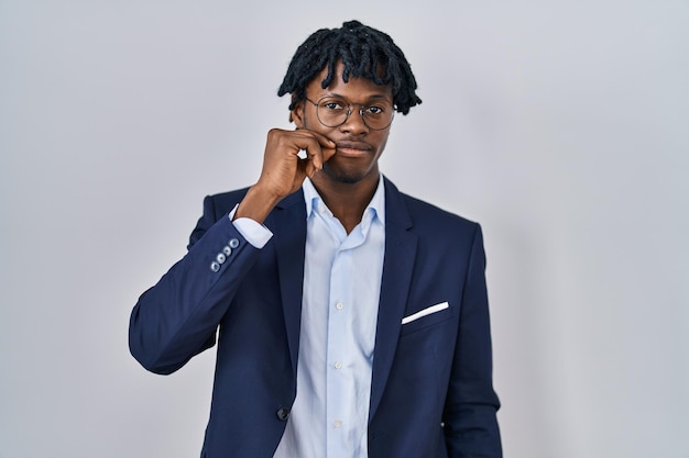 Young african man with dreadlocks wearing business jacket over white background mouth and lips shut as zip with fingers. secret and silent, taboo talking