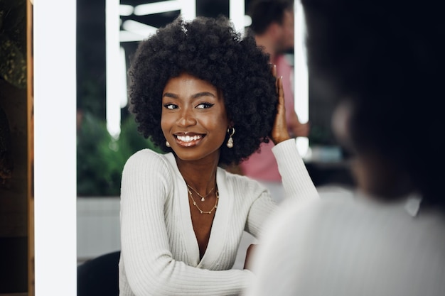 Young african woman customer getting a hairstyle at a beauty salon