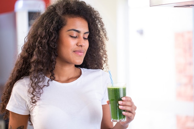 Young african woman enjoy healthy vegetarian smoothie for weight loss and detox  