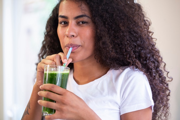 Young african woman enjoy healthy vegetarian smoothie for weight loss and detox  