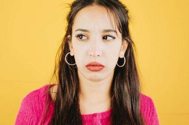 Young african woman looking away from camera sad and worried about something mental health concept posing isolated over yellow color wall background Daily expressions with copy space in studio