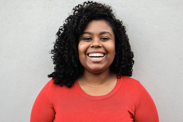 Young african woman smiling on camera outdoor in the city - Focus on face