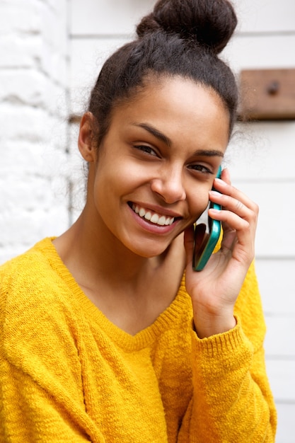 Young african woman talking on mobile phone at cafe