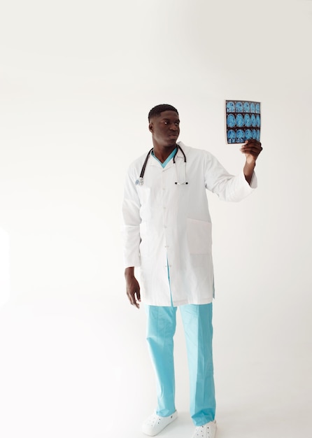 A young AfricanAmerican male doctor reads and views an MRI scan of the brain