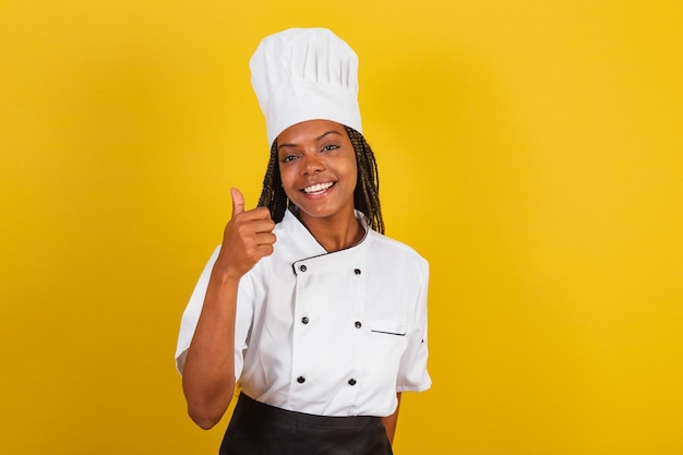 Young afro brazilian woman chef with thumb up approval like affirmative