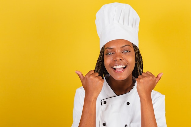 Young afro brazilian woman chef with thumb up approval like affirmative