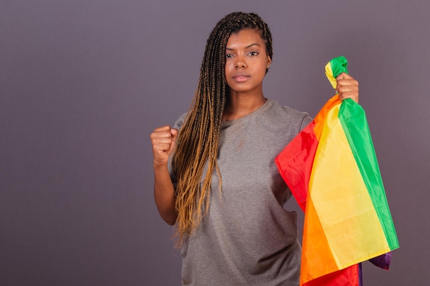 Young afro brazilian woman holding LGBT LGBTQ flag in the form of militancy Empowerment of diversity