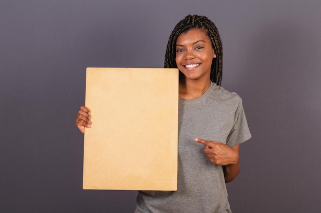 Young afro brazilian woman holding sign for text or announcement advertising photo