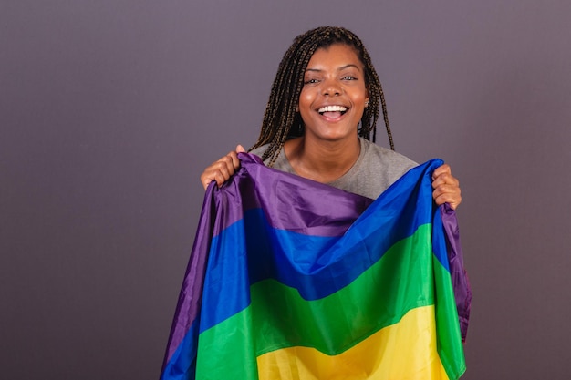 Young Afro Brazilian woman LGBT flag LGBTQ bisexual celebrating victory for the cause diversity