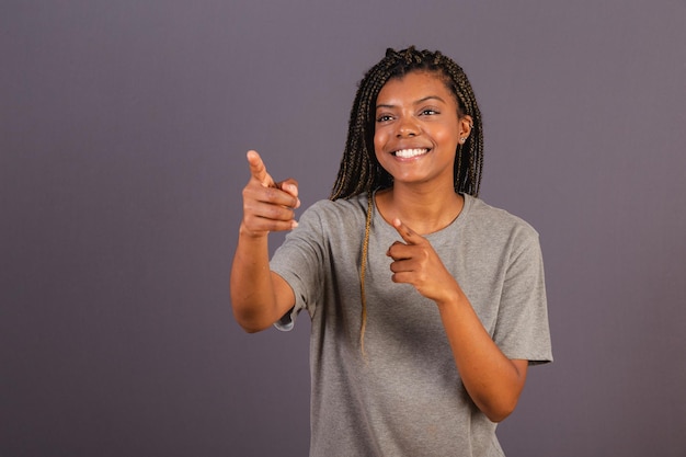 Young afro brazilian woman pointing something far away with fingers advising pointing direction