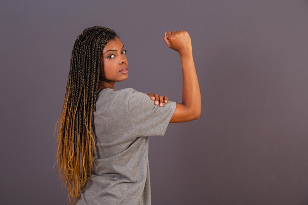 Young afro brazilian woman showing clenched fist sign of militancy female empowerment feminism